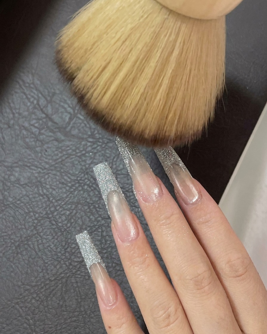 Une brosse douce et duveteuse balayant les ongles pour éliminer les traces finales de poudre de paillettes libre.