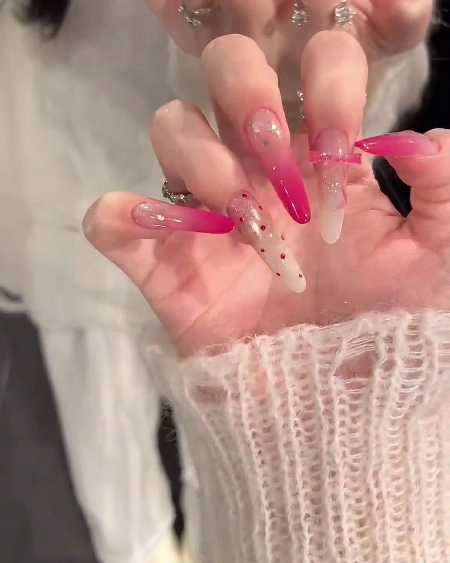 Gros plan dune main appliquant un pinceau à ongles avec une base nude sur des ongles propres et préparés.