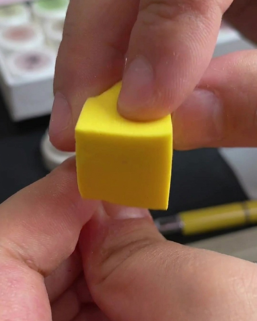 Une main plaçant ses ongles sous une lampe professionnelle UV/LED pour catalyser.