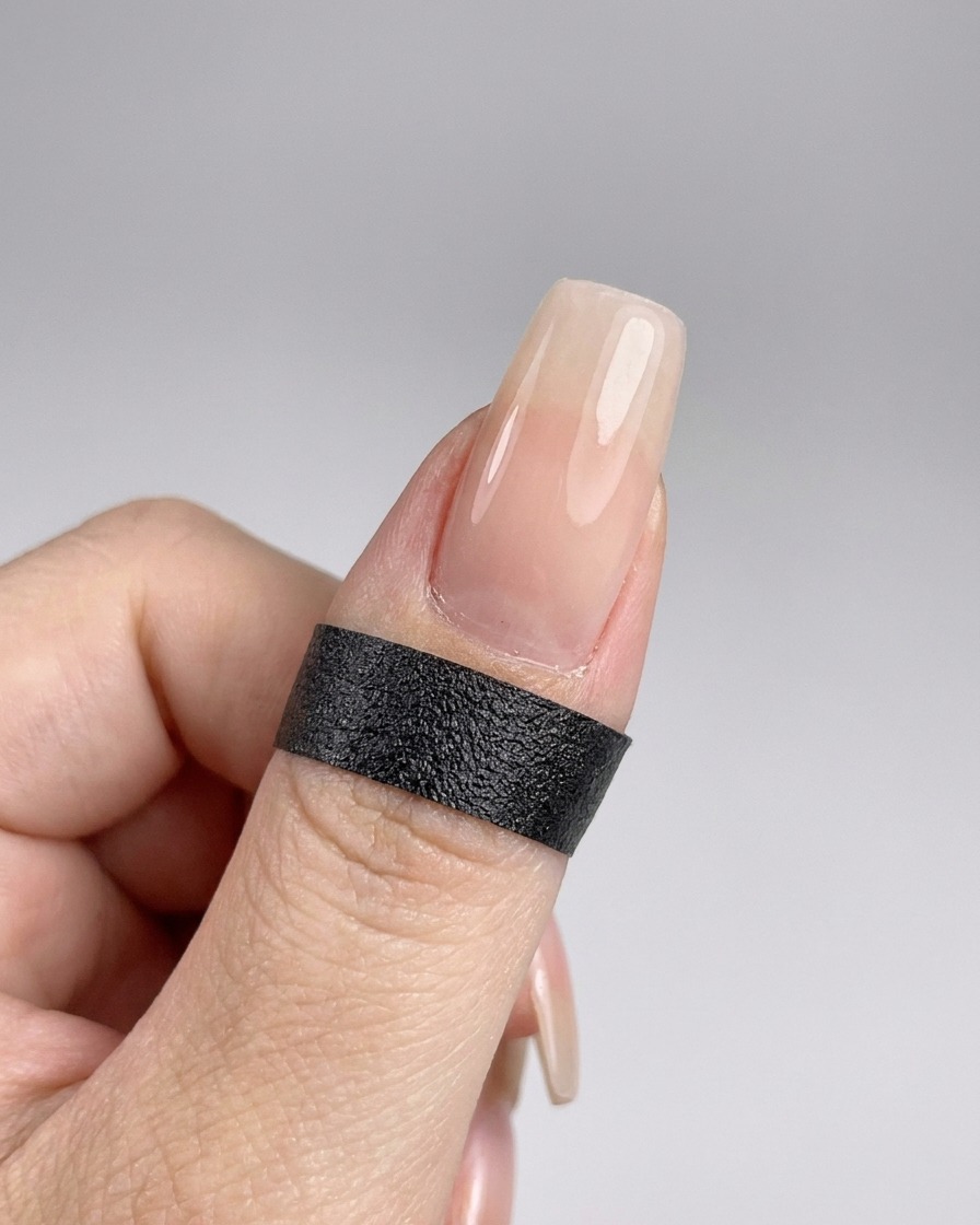 Une main positionnée à lintérieur dune lampe UV pour polymériser le top coat fraîchement appliqué.