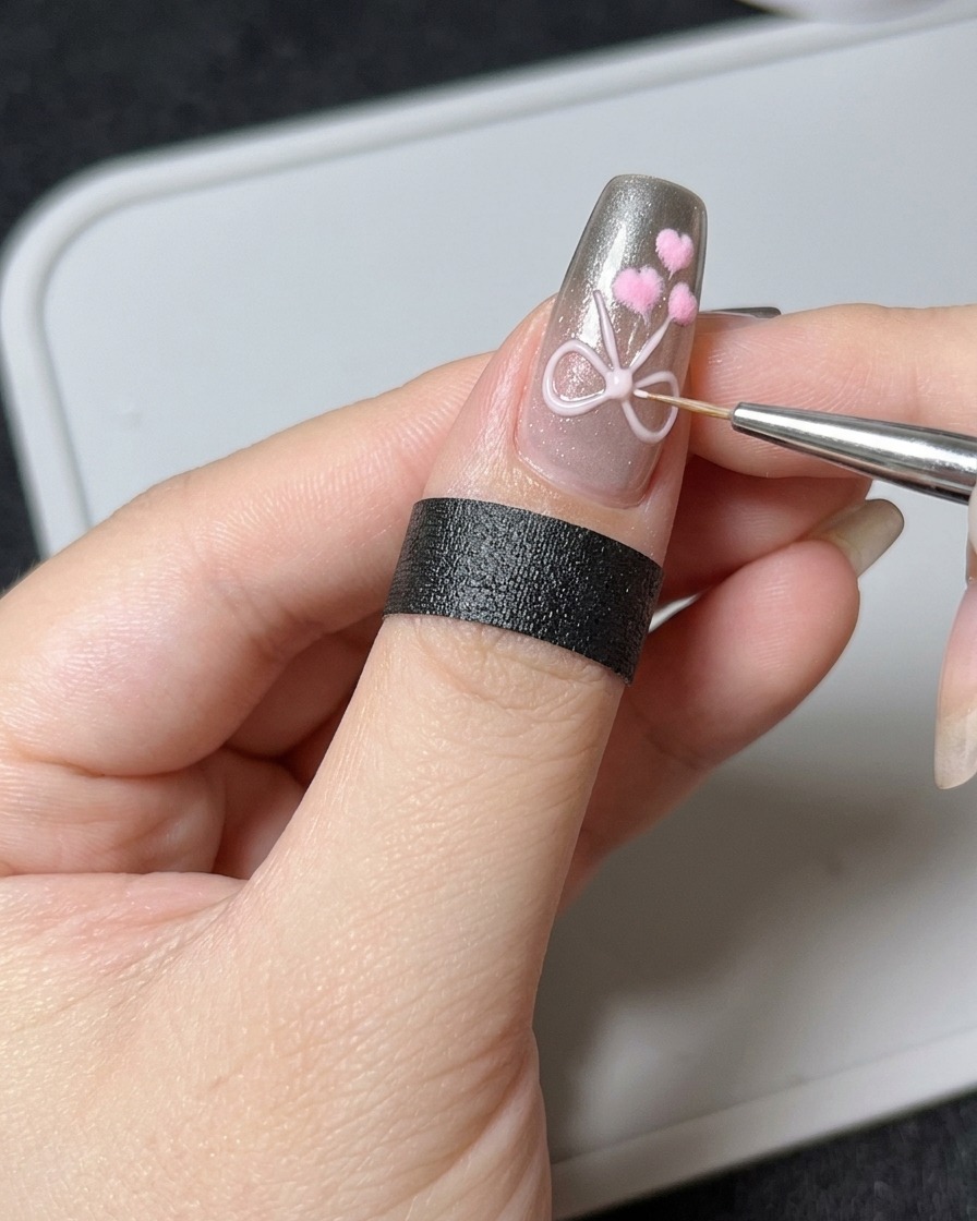 Un pinceau liner fin ajoutant une perle précise de gel de sculpture 3D épais sur un design de nœud existant sur un ongle.