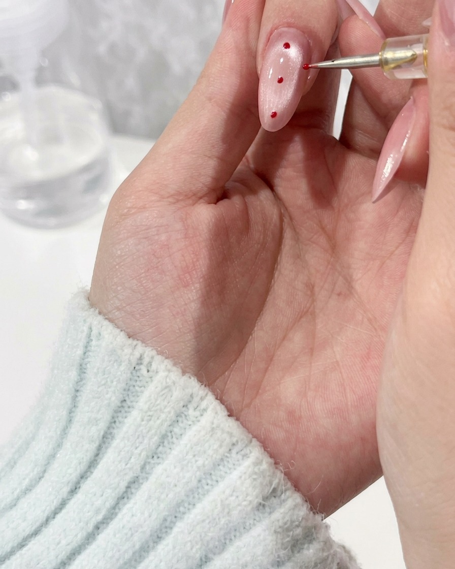 Vue rapprochée dun pinceau de détail appliquant une perle de gel transparent sur un ongle manucuré.
