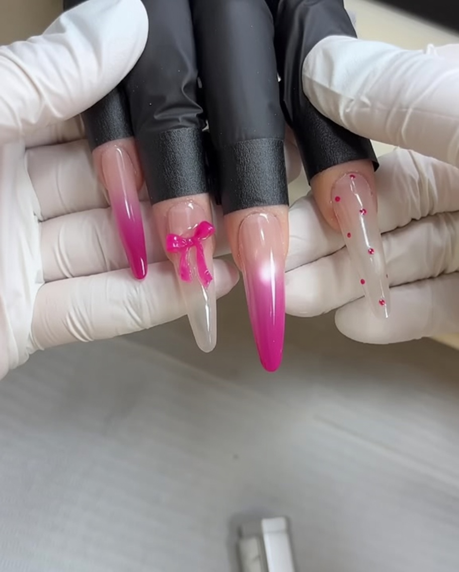 Une éponge de maquillage appliquant du vernis gel rose sur un ongle pour un effet dégradé.