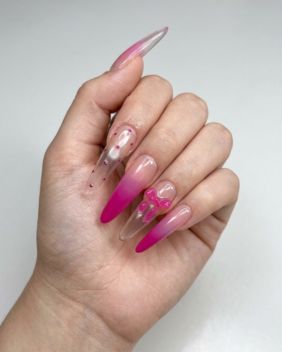 Une pince déposant un petit nœud 3D rose sur la surface dun ongle manucuré.