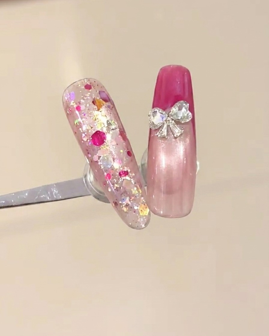 Deux petits strass en forme de cœur placés à la base de la French pour créer un design de nœud.