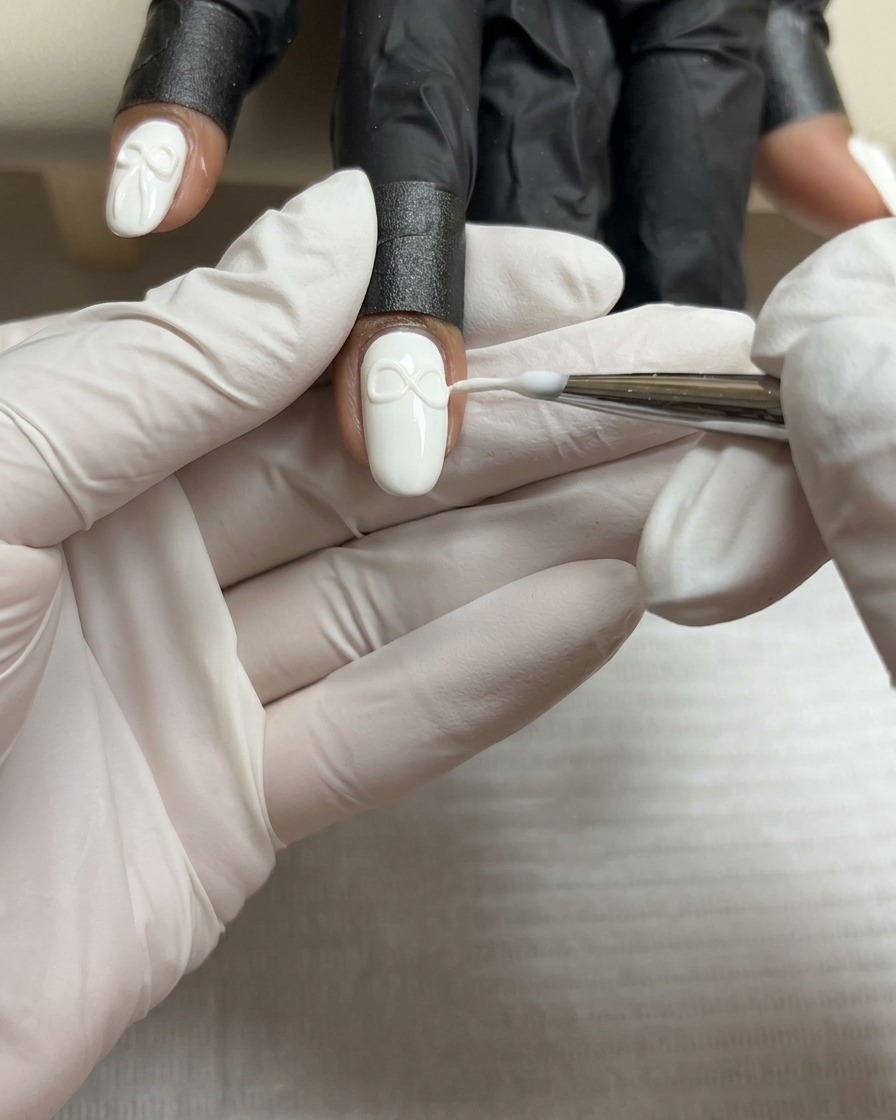 Un pinceau fin façonnant la seconde aile dun nœud en gel 3D pour laligner avec la première.