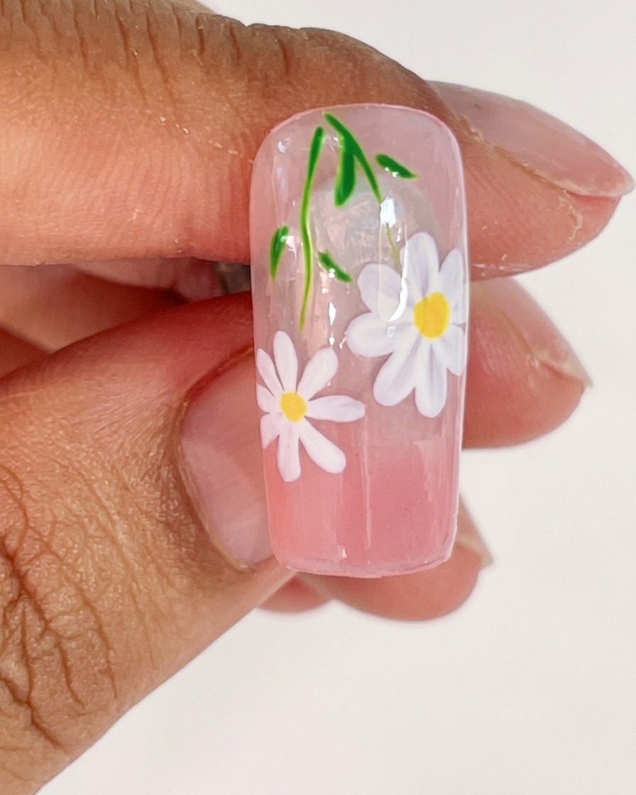 Une capsule dongle placée sous une lampe UV pour catalyser les pétales blancs fraîchement peints.