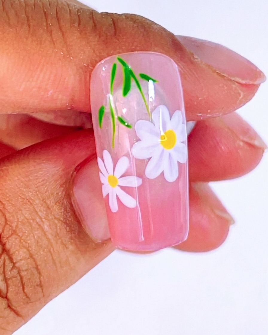 Vue du nail art montrant la deuxième marguerite avec son cœur jaune, prête pour la catalyse finale.