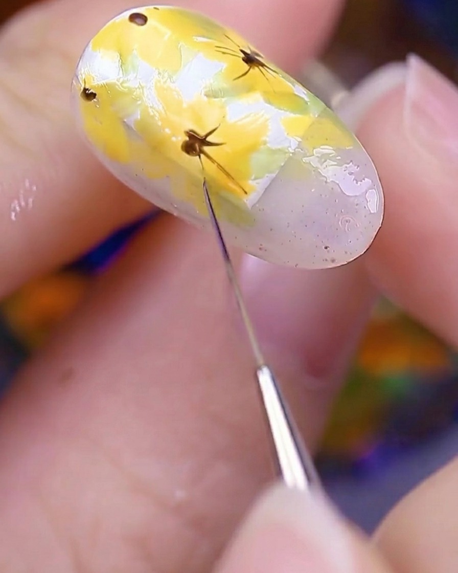 Gros plan de longle peint sous une lampe UV pour fixer les détails floraux.