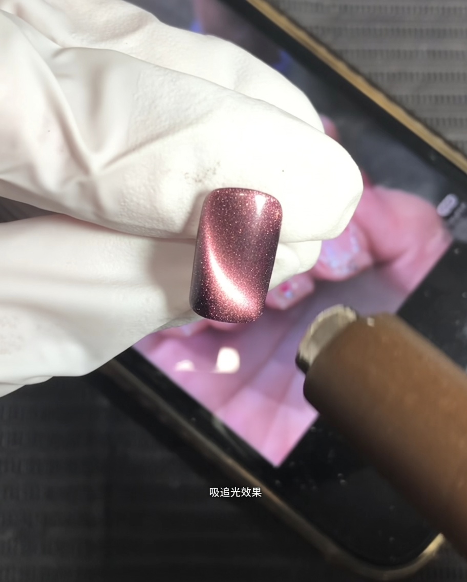 Un aimant placé au-dessus dun ongle recouvert de gel œil de chat pour créer un reflet central lumineux.