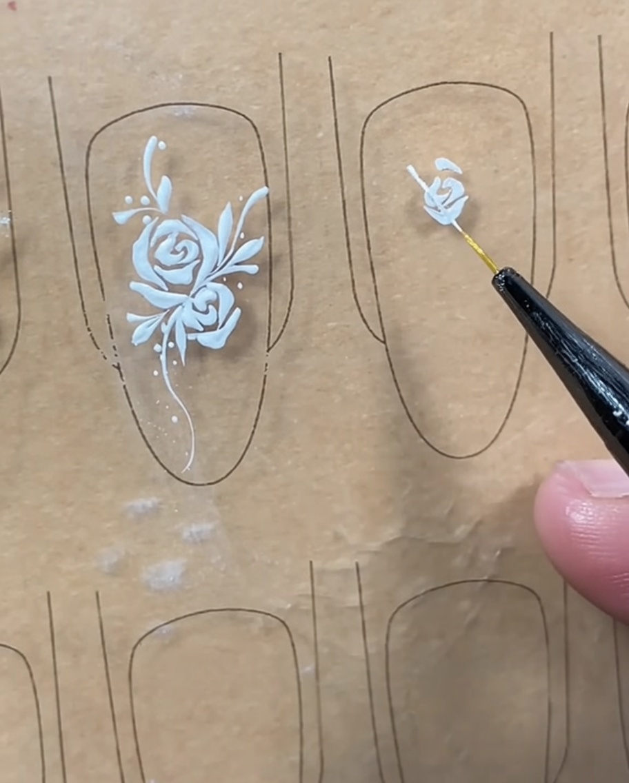 Un pinceau liner terminant le bouton central en dessinant une ligne courbe miroir sur le côté droit.
