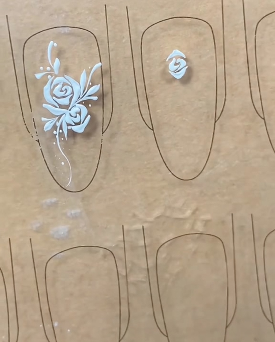 Un pinceau liner dessinant une ligne de pétale en forme darc au-dessus du bouton central établi.