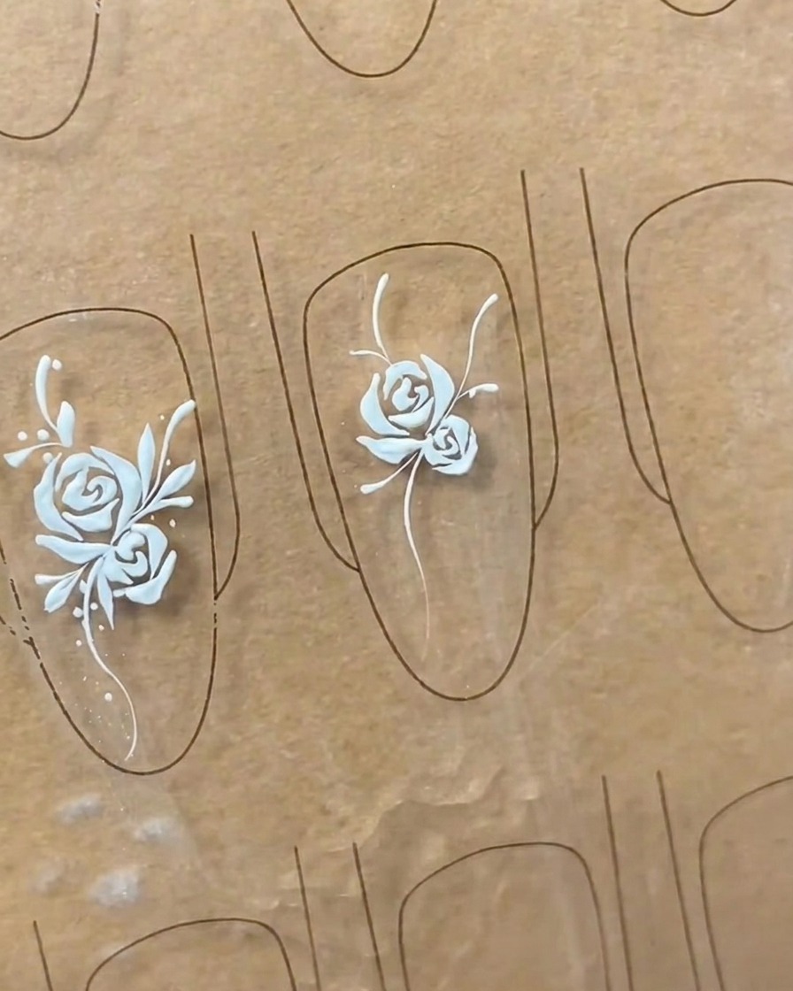 Gros plan montrant le raffinement des formes de feuilles sur un nail art, ajoutant du détail et du relief.