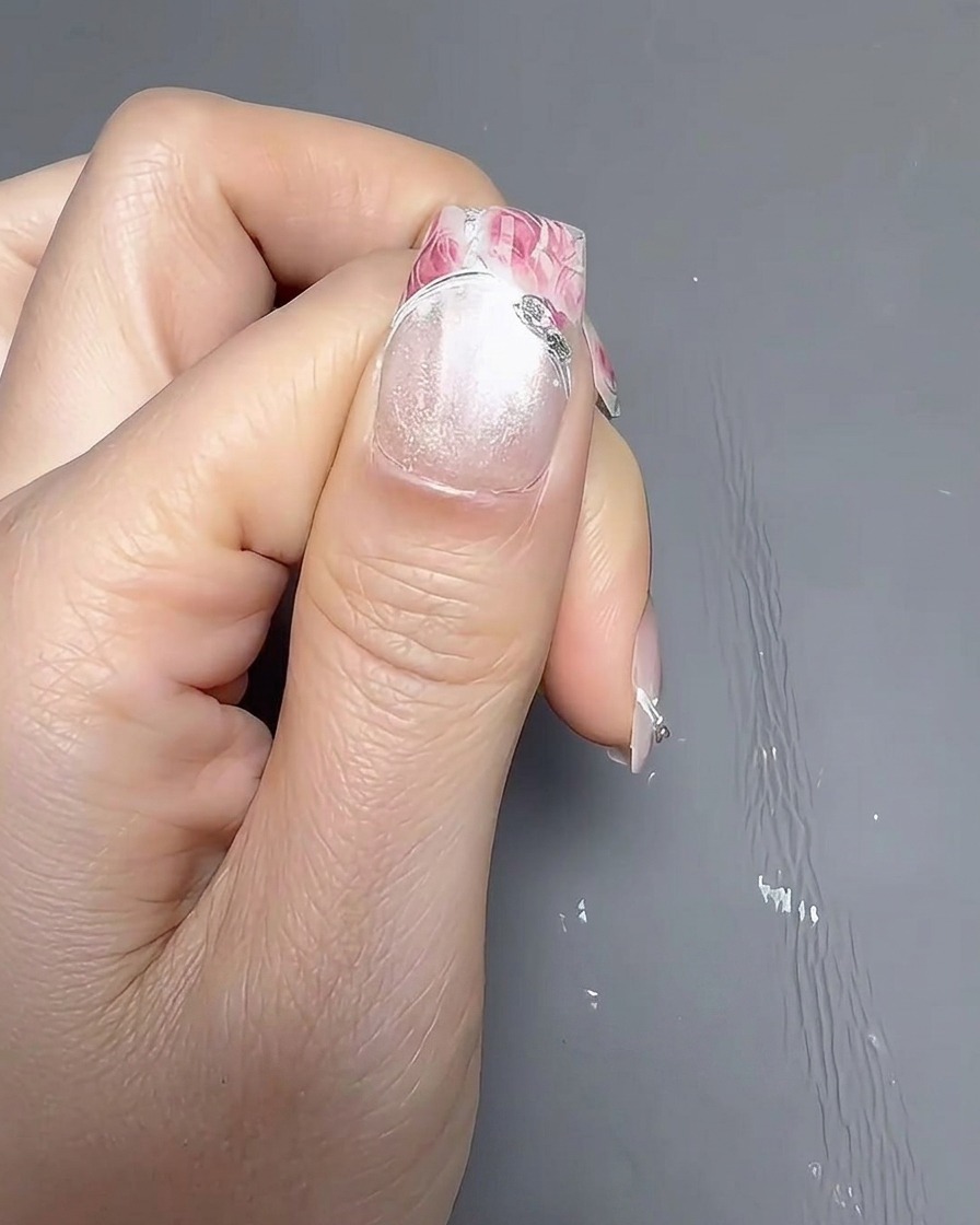 Gros plan dun pinceau appliquant une couche uniforme de vernis blanc opaque sur longle naturel.