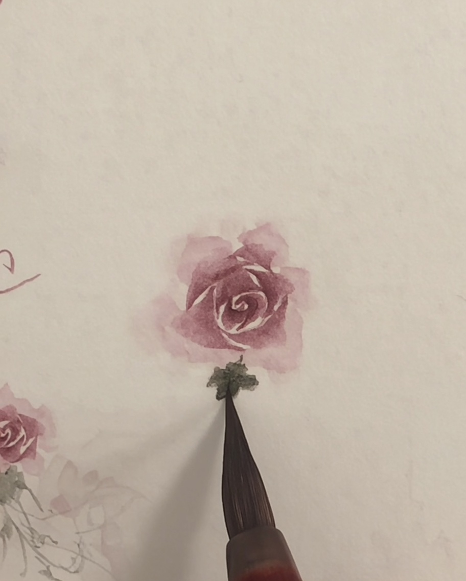 Un pinceau propre estompant légèrement les bords dune rose aquarelle rose sur papier blanc.
