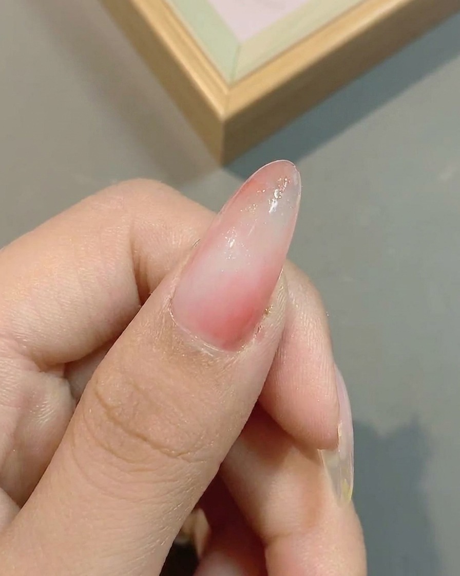 Surface de longle montrant lapplication de paillettes effet nuage sur le dégradé rose existant.