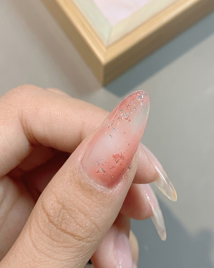 Gros plan montrant le reflet métallique du gel platine argenté n° 04 appliqué sur longle rose pailleté.