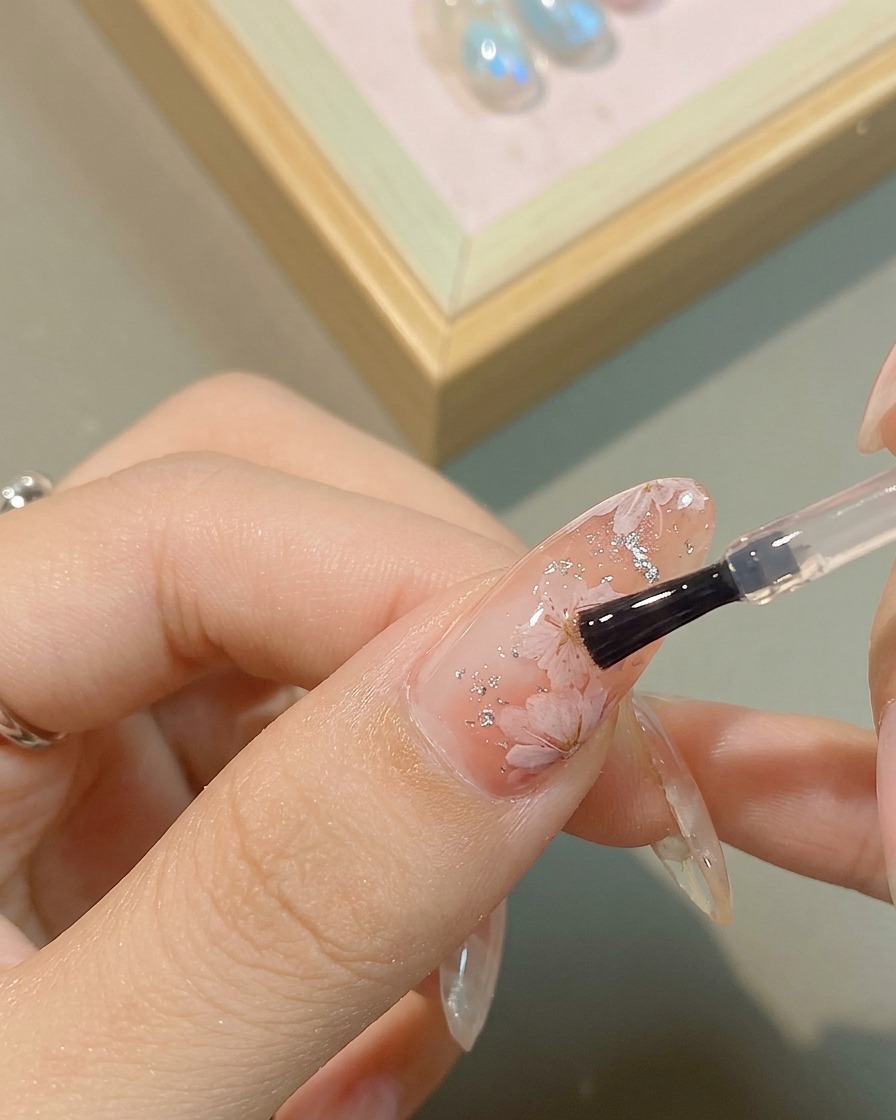 Un plan de détail dun gel argenté métallique appliqué au cœur dune fleur peinte.