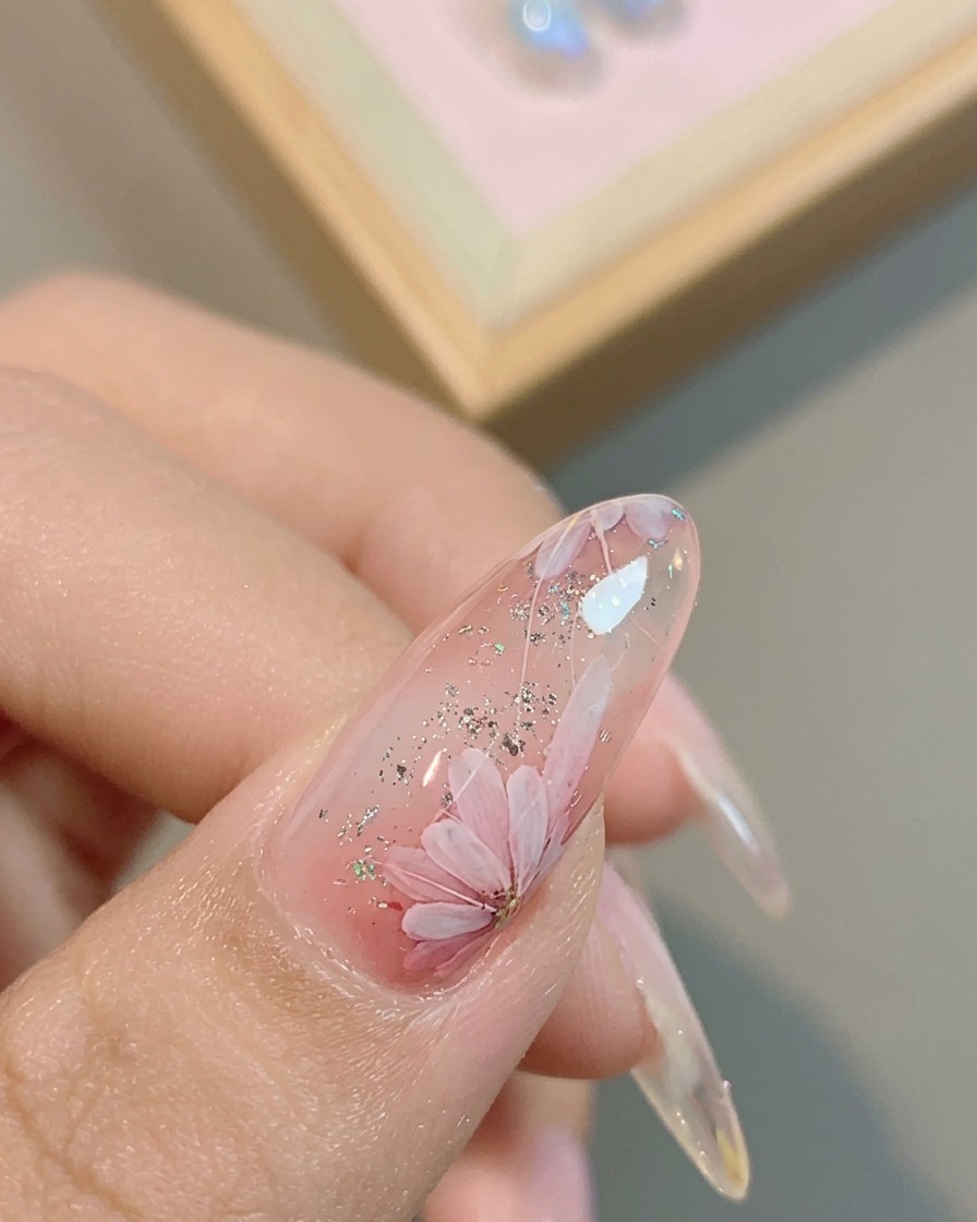 Un pinceau appliquant une dernière couche de finition brillante sur le design de marguerite terminé.