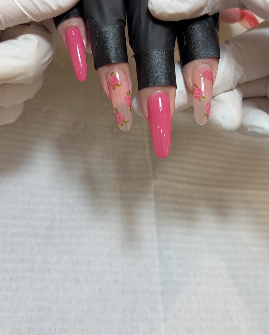 Gros plan dun pinceau appliquant du gel rouge foncé au centre du deuxième groupe de rose.