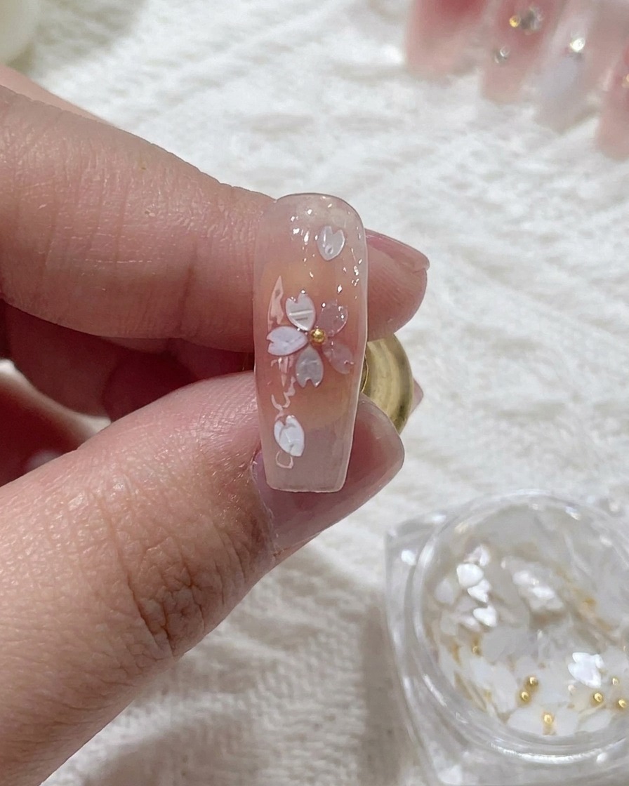 Une perle métallique placée au centre de la fleur en sequin.