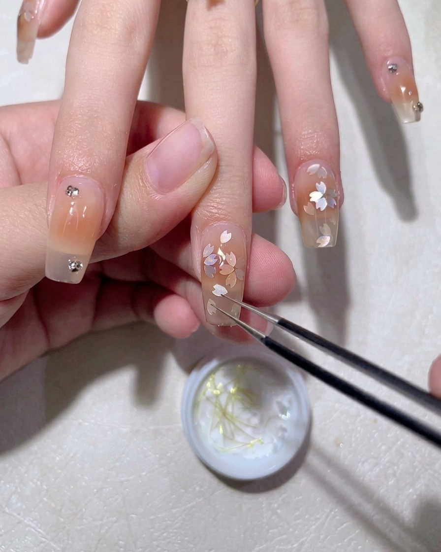 Un pinceau appliquant du top coat brillant sur le design fini.