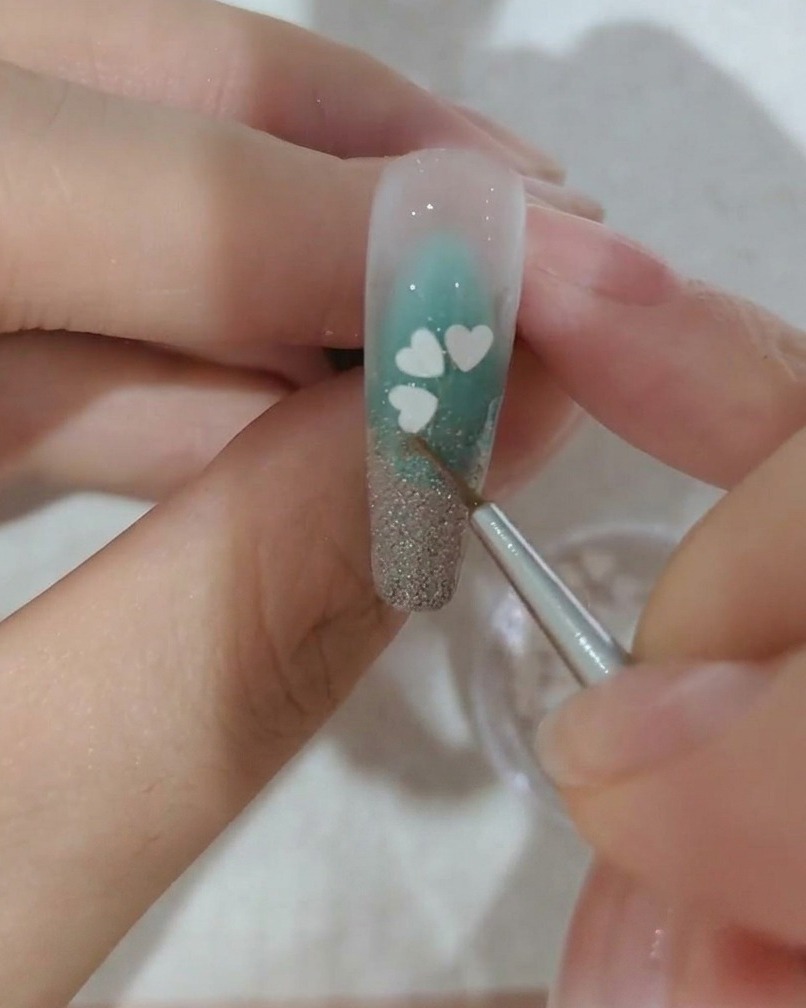 Gros plan dun ongle décoré dun troisième pétale blanc.