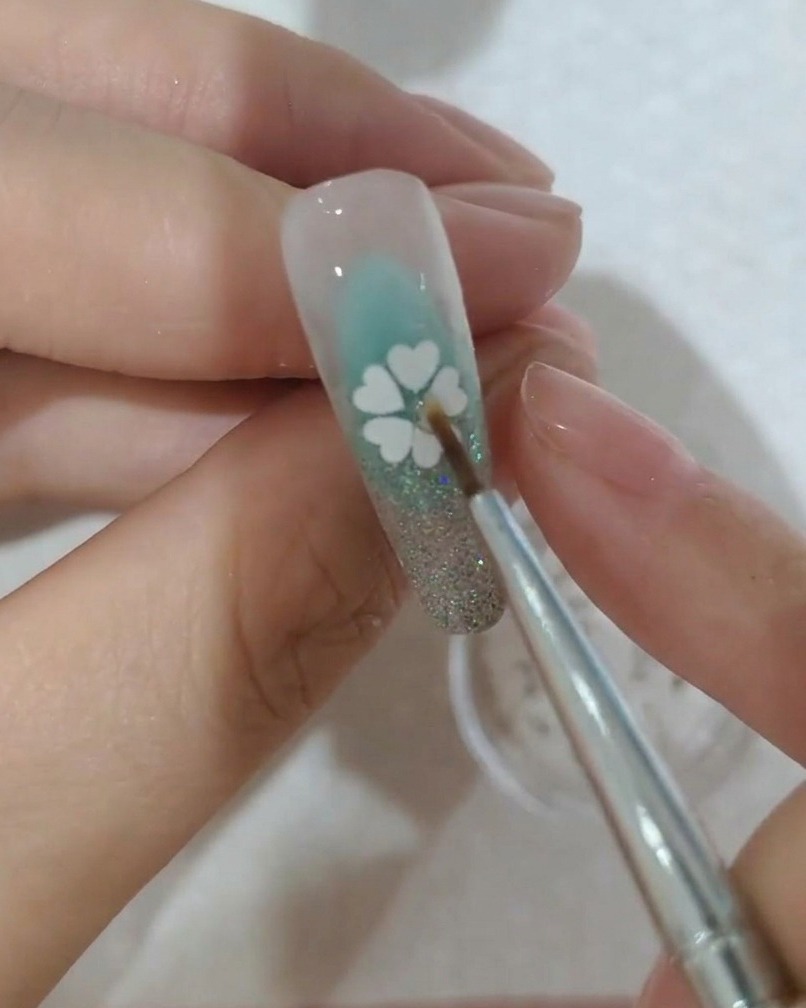 Gros plan de la pose dun petit cristal au centre de la fleur.