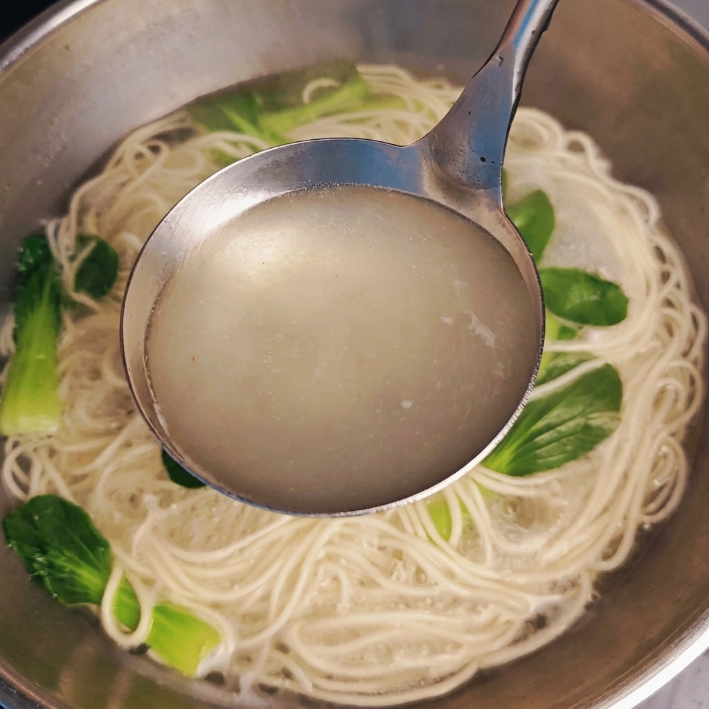 Une main avec des ongles longs en dégradé tenant un téléphone blanc pour montrer la longueur et la courbure structurelle des pointes.