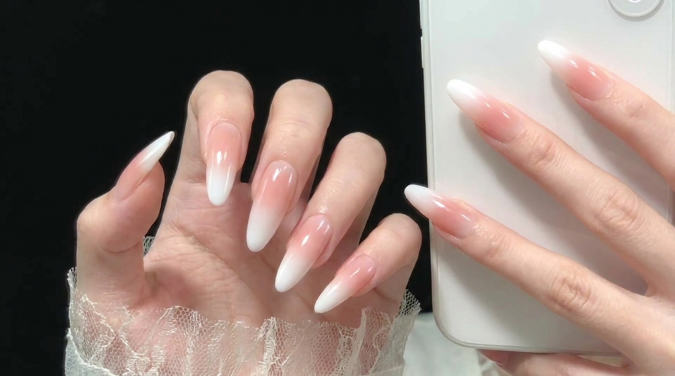 Un pinceau applique une base transparente sur un ongle propre et préparé.