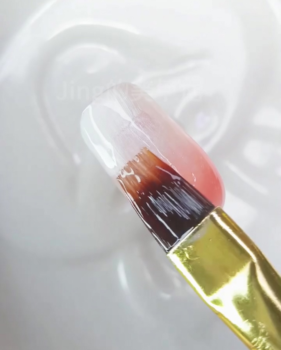 Gros plan dun ongle montrant un dégradé lisse et fini, du blanc vers le rose pêche.