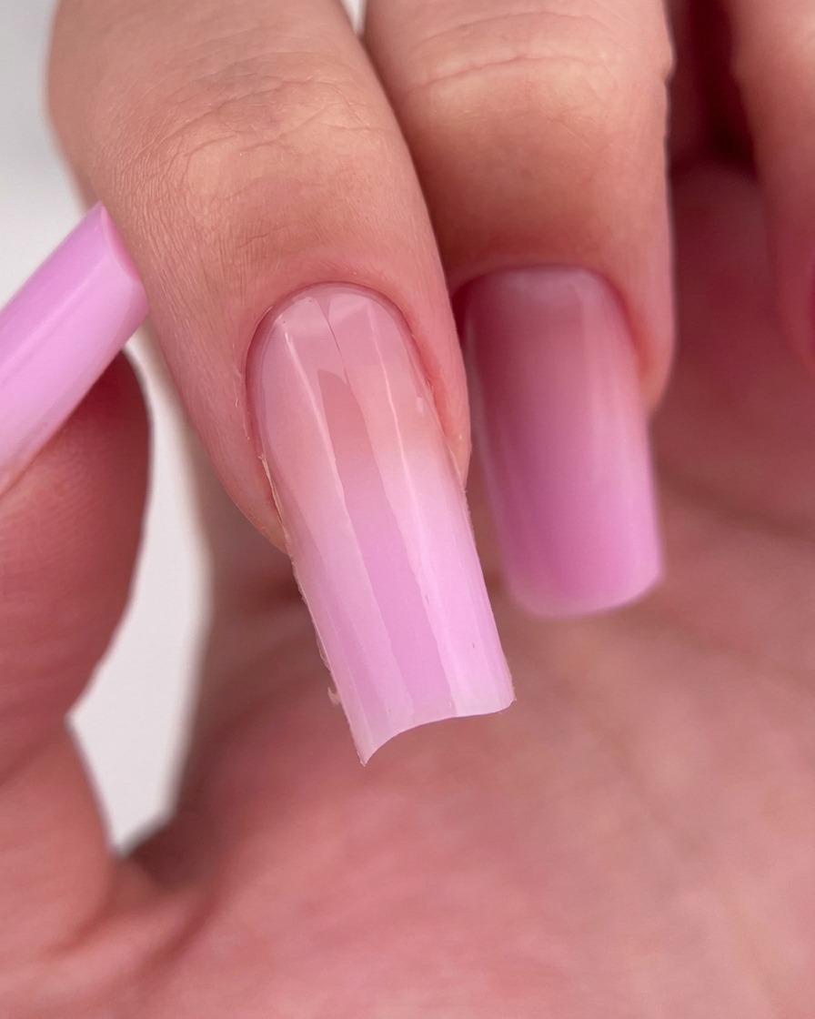 Doigt avec une couche de base transparente appliquée sur longle.