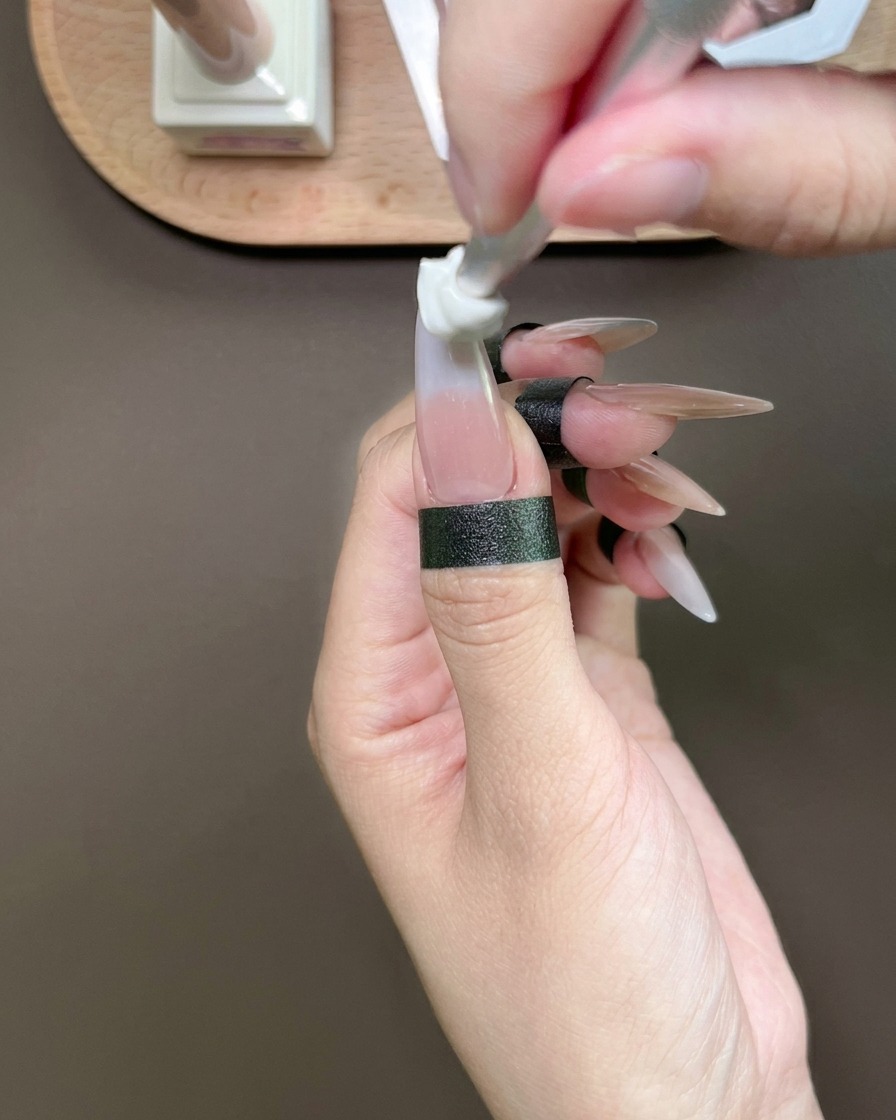 Une éponge tamponnant du gel bleu sur le bout dun pouce pour créer un dégradé.