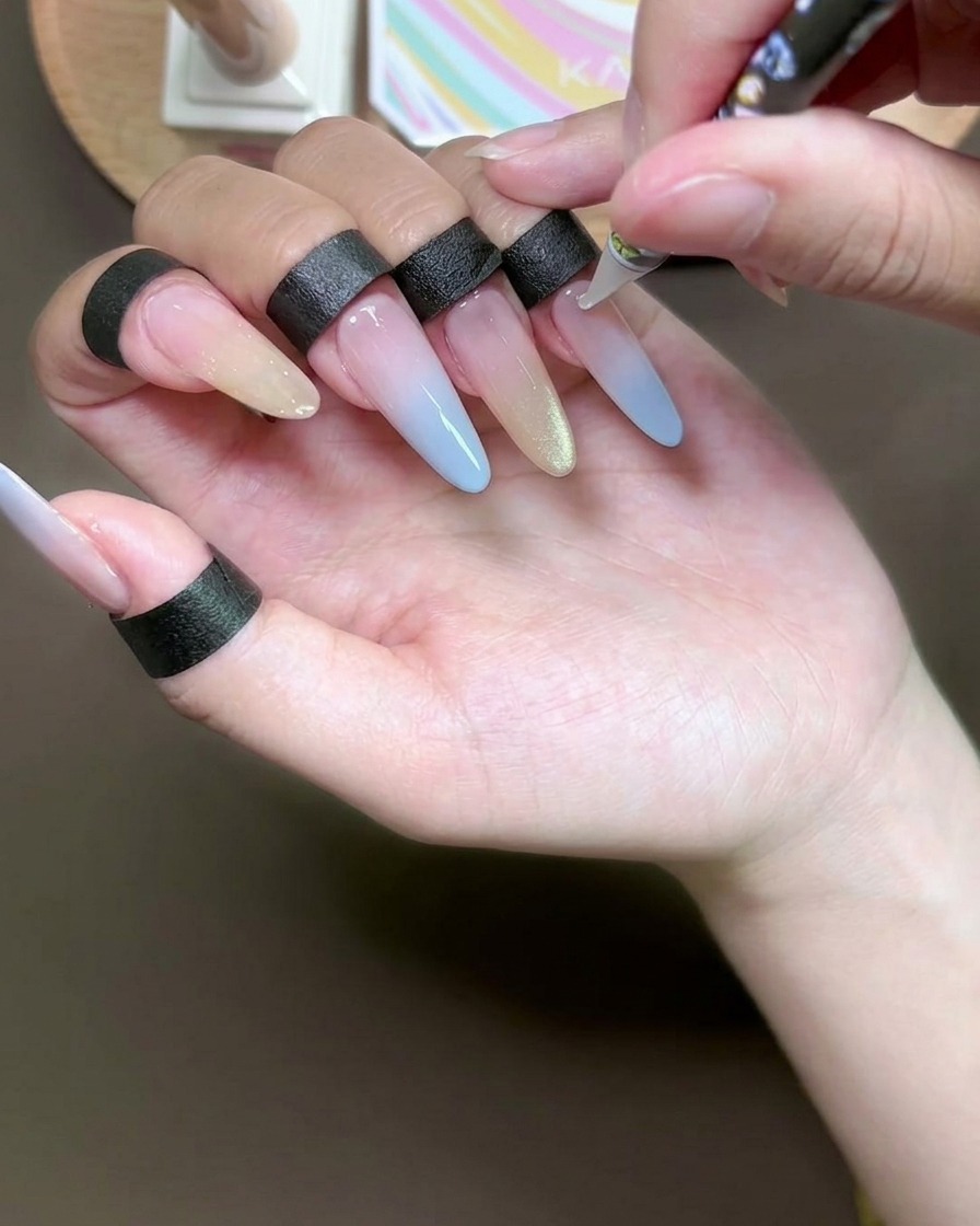 Gros plan dun outil à pointillés appliquant de minuscules points dadhésif transparent sur un ongle.
