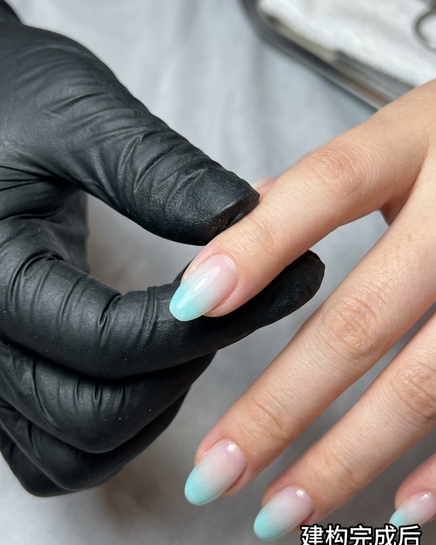 Une éponge à maquillage tapotant du vernis gel bleu et beige sur un ongle pour créer un effet ombré.