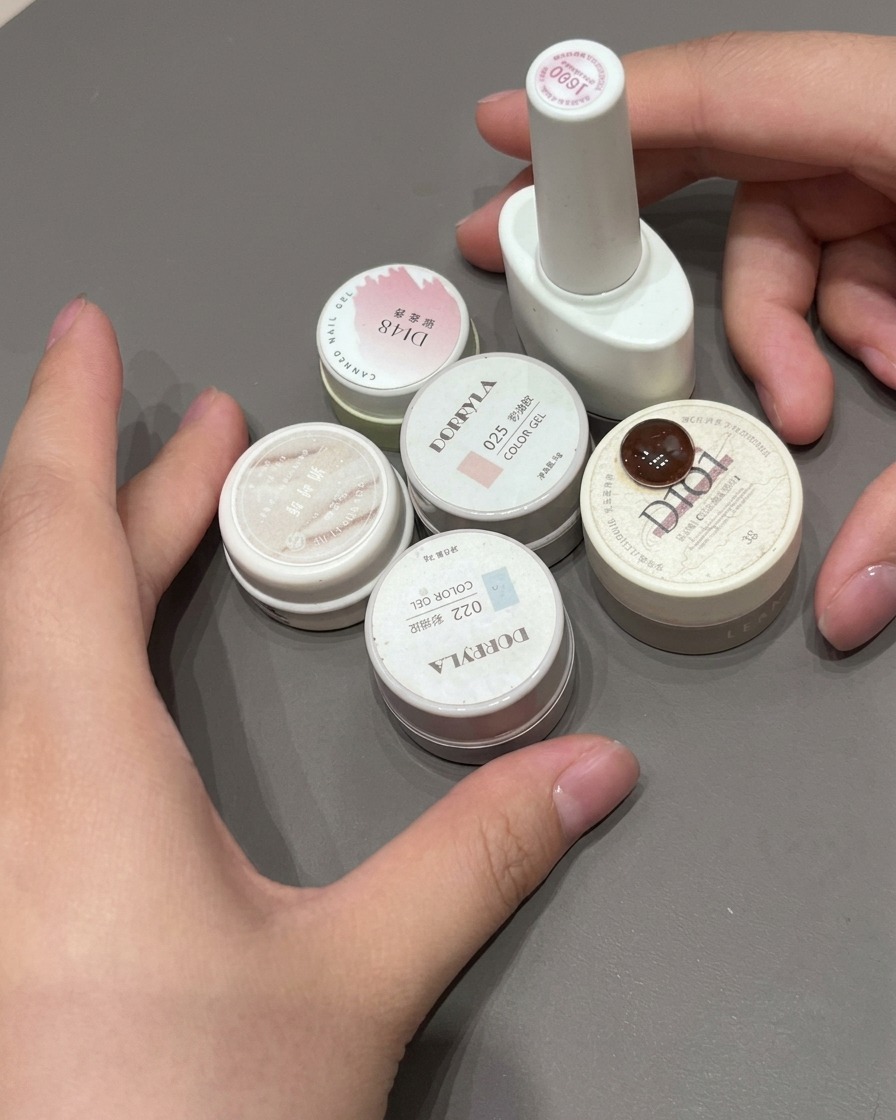 Une dernière couche de top coat brillant appliquée sur un ongle French avec un dégradé rose.