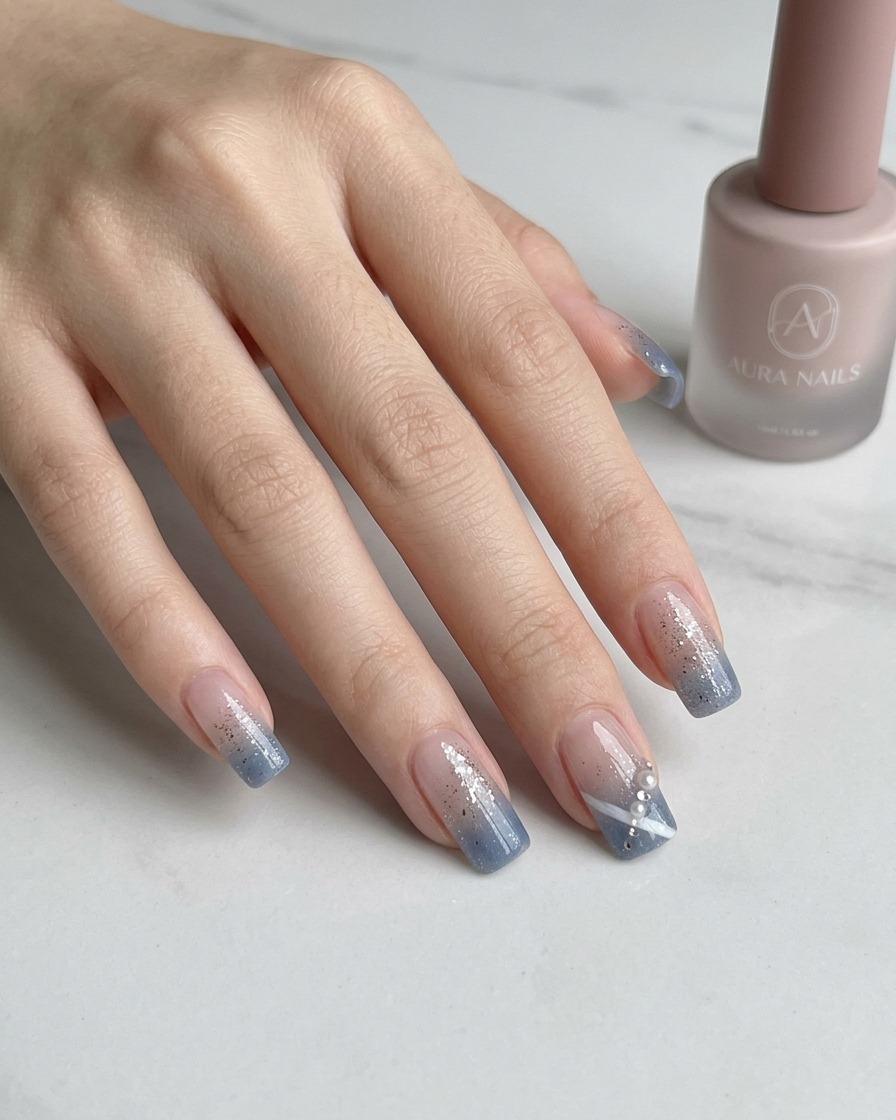 Une pince à épiler plaçant un petit strass étincelant sur un ongle décoré.
