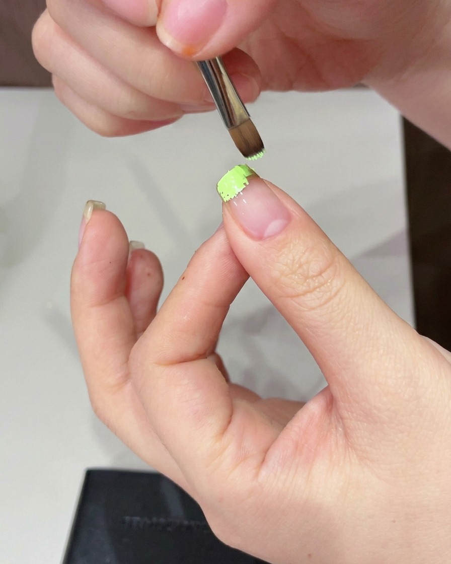 Une éponge utilisée pour tapoter et adoucir le gel vert sur le bout de longle.