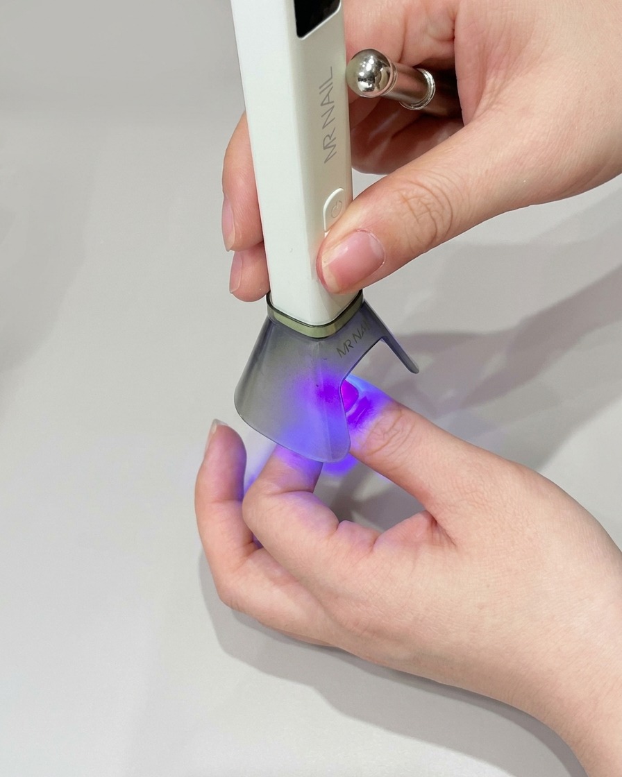 Une petite éponge à maquillage appliquant du gel vert sur le bout de longle pour renforcer la couleur.