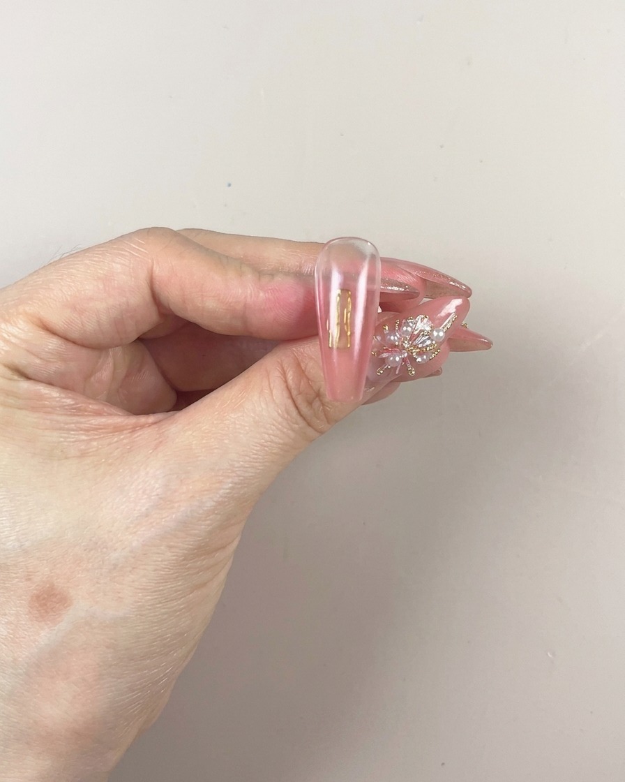 Un pinceau appliquant une nouvelle couche de gel de patinage pigmenté sur la partie inférieure de longle.