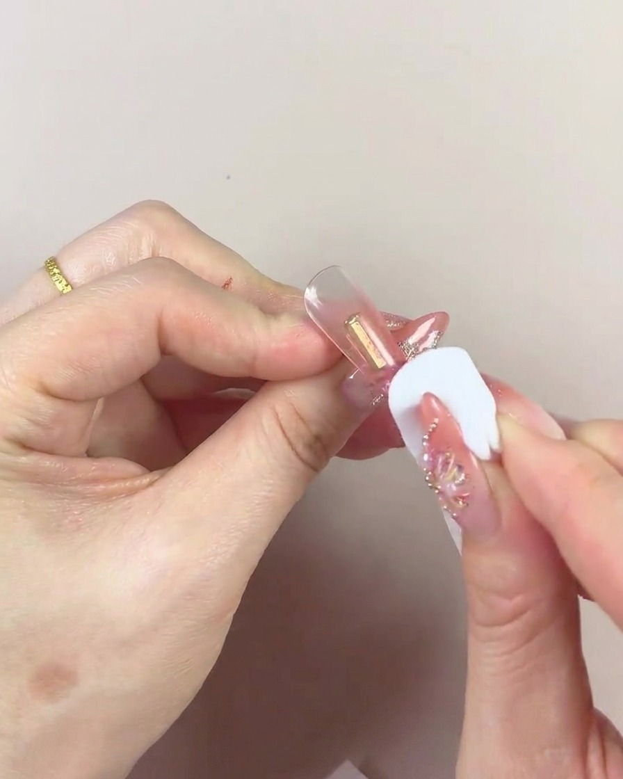 Gros plan dune éponge cosmétique avec un centre foncé utilisée pour tapoter du gel sur une pointe dongle.