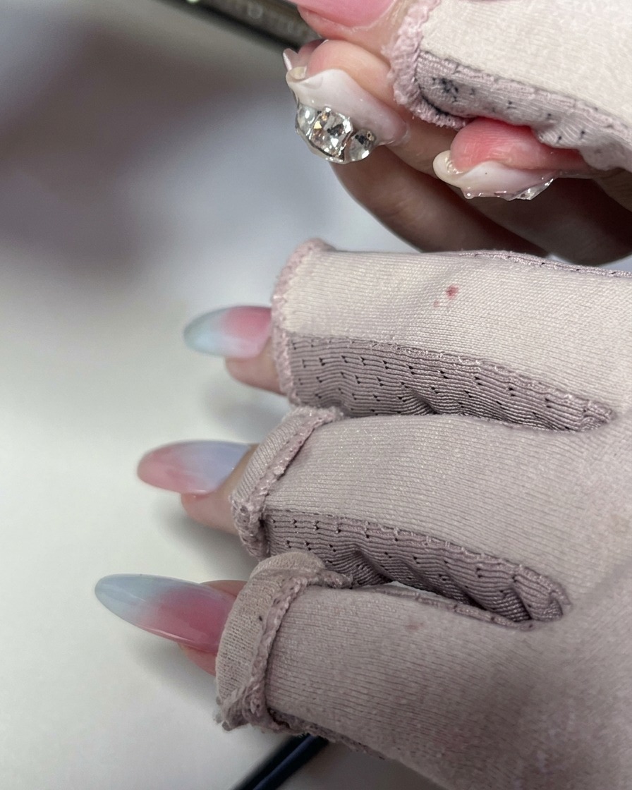 Une éponge tapotant légèrement la surface de longle pour lisser le dégradé en gel.