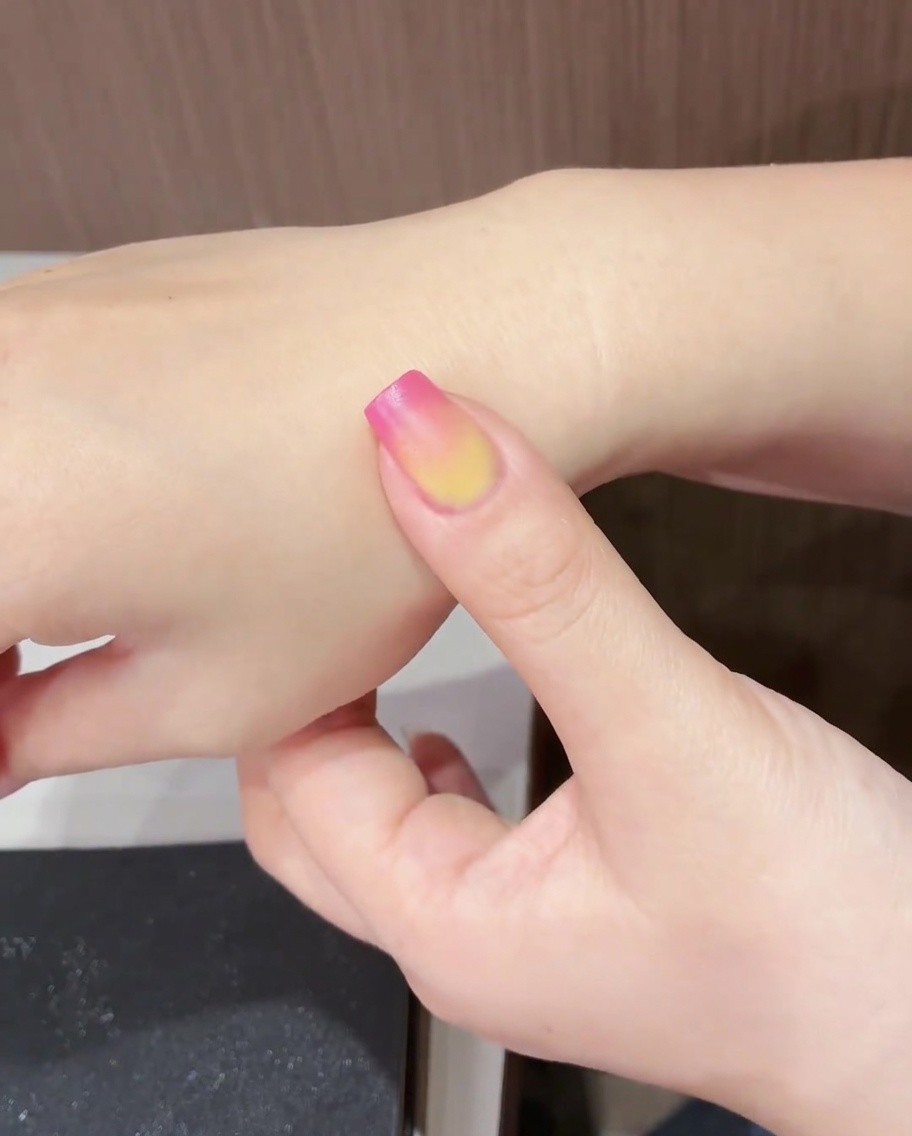 Un ongle avec le design tulipe terminé sous une lampe UV/LED.
