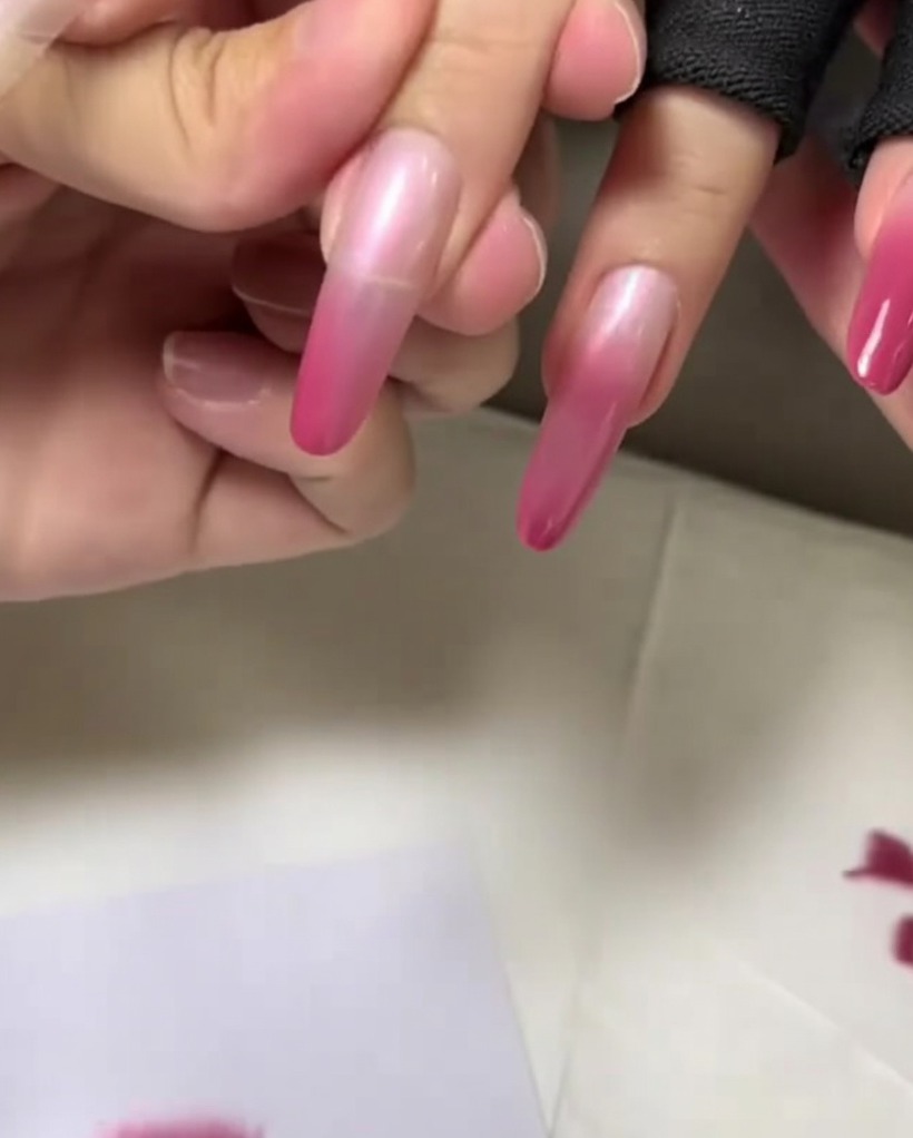 Gros plan sur le bout de longle tapoté avec la dernière couche de rose la plus foncée pour finaliser le dégradé.