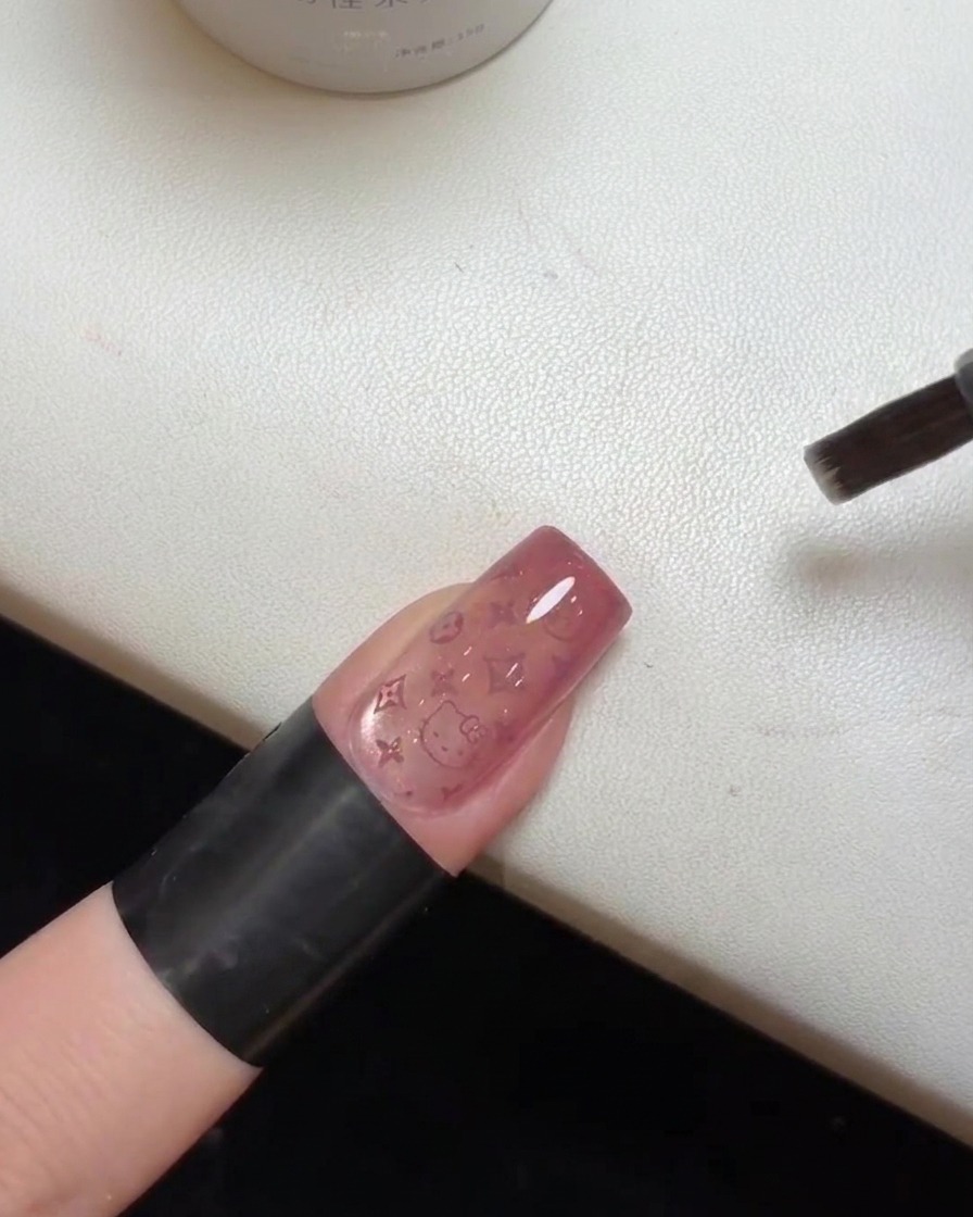 Gros plan dun ongle terminé avec la couche de finition catalysant sous une lampe UVcite: 1.