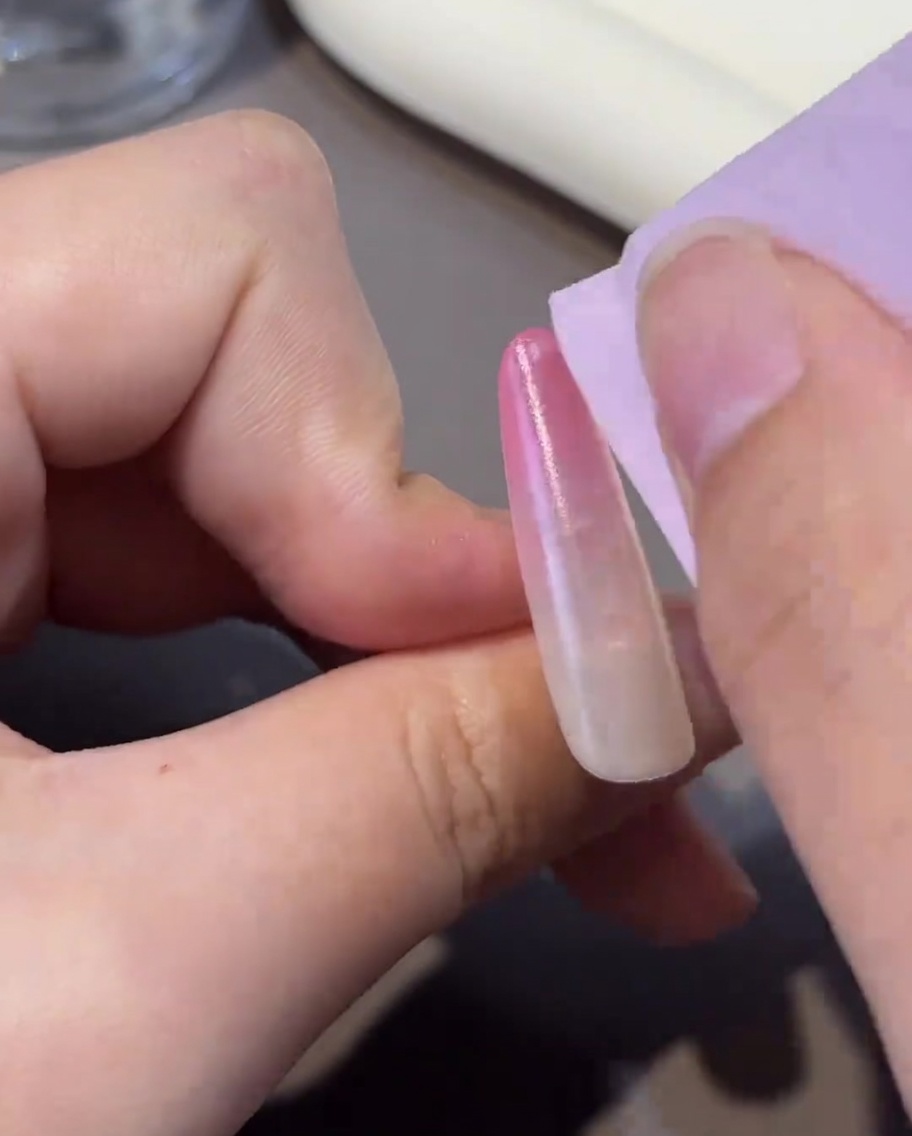 Un coton non pelucheux nettoyant la surface dun ongle catalysé, le rendant propre pour létape suivante.