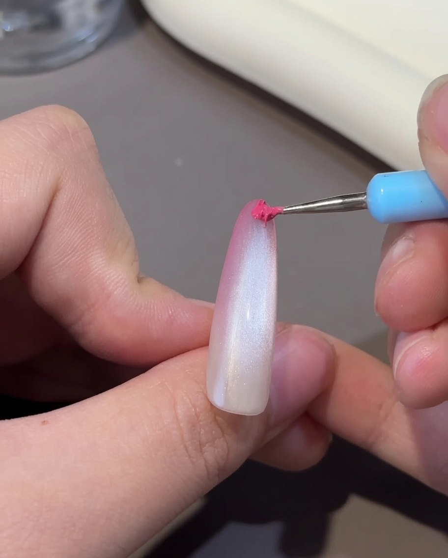 Un ongle avec leffet œil-de-chat en cours de catalysation sous lampe UV/LED.