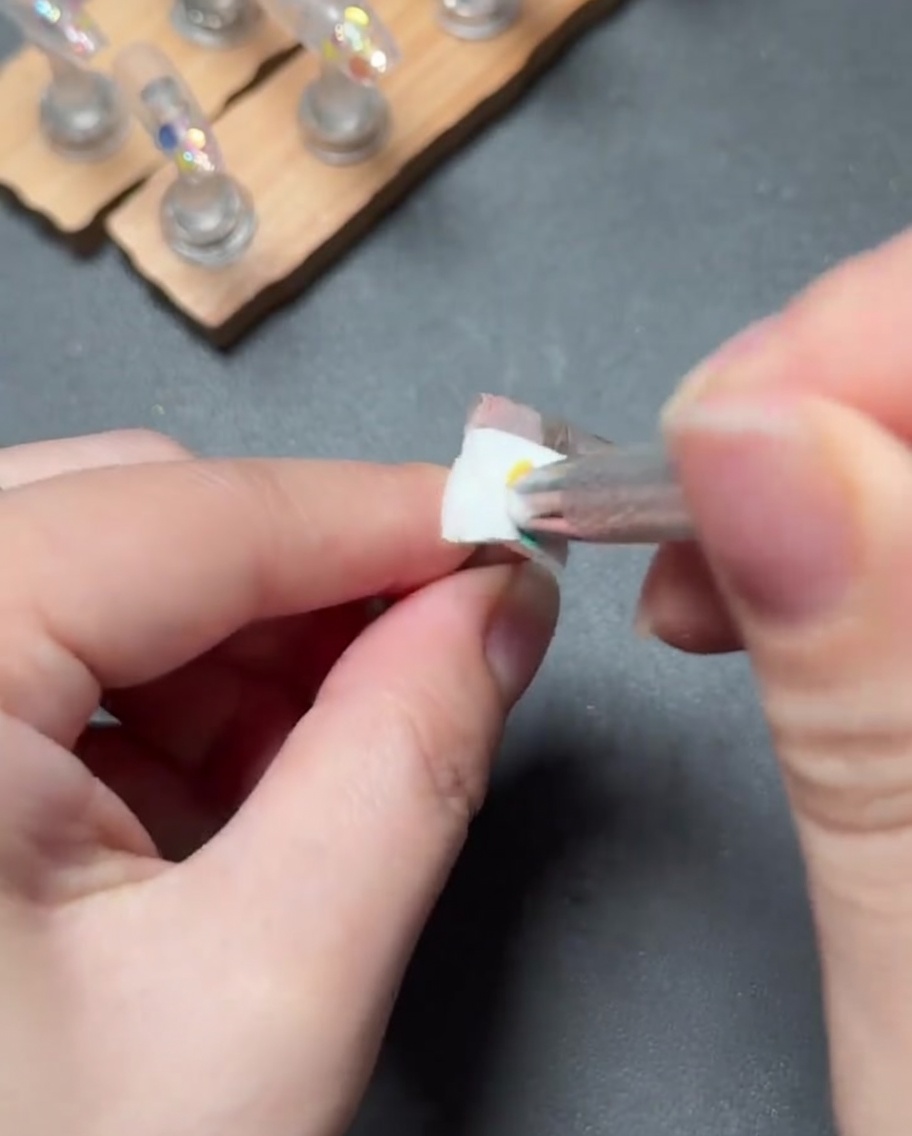 Un petit pinceau tapotant du gel rose clair pour créer un dégradé fluide de la cuticule vers le bas de longle.