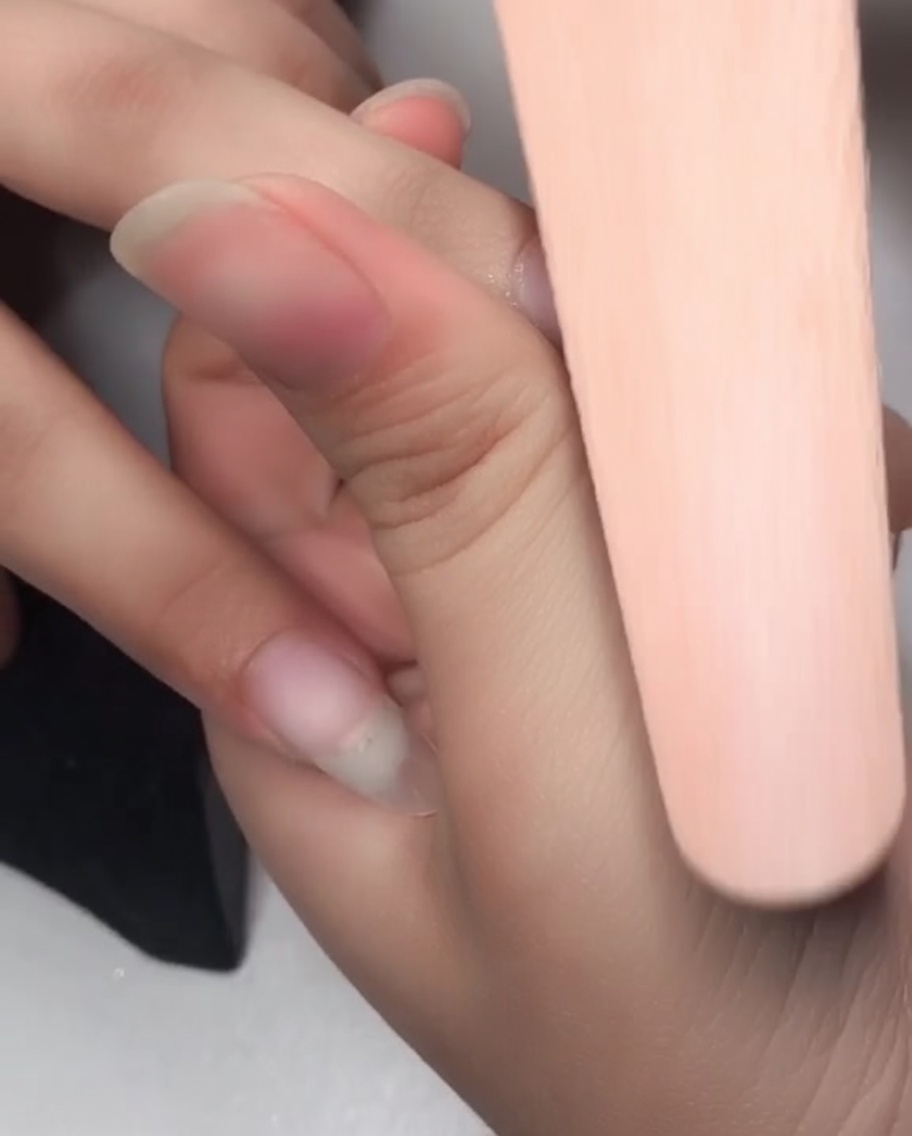 Gros plan dune lime éponge ponçant la surface dun ongle pour préparer lapplication du gel.