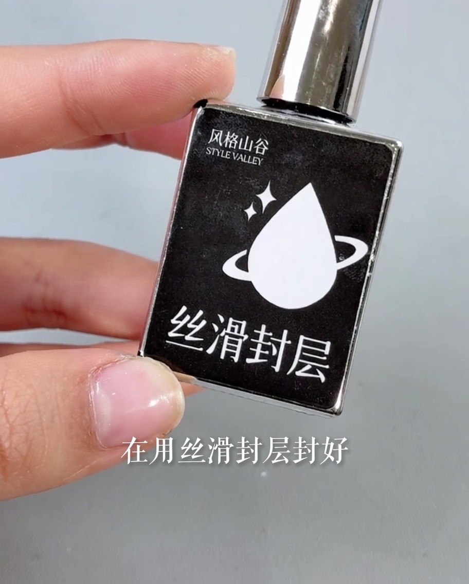 Un pinceau appliquant un top coat transparent et brillant sur un design dongle terminé.
